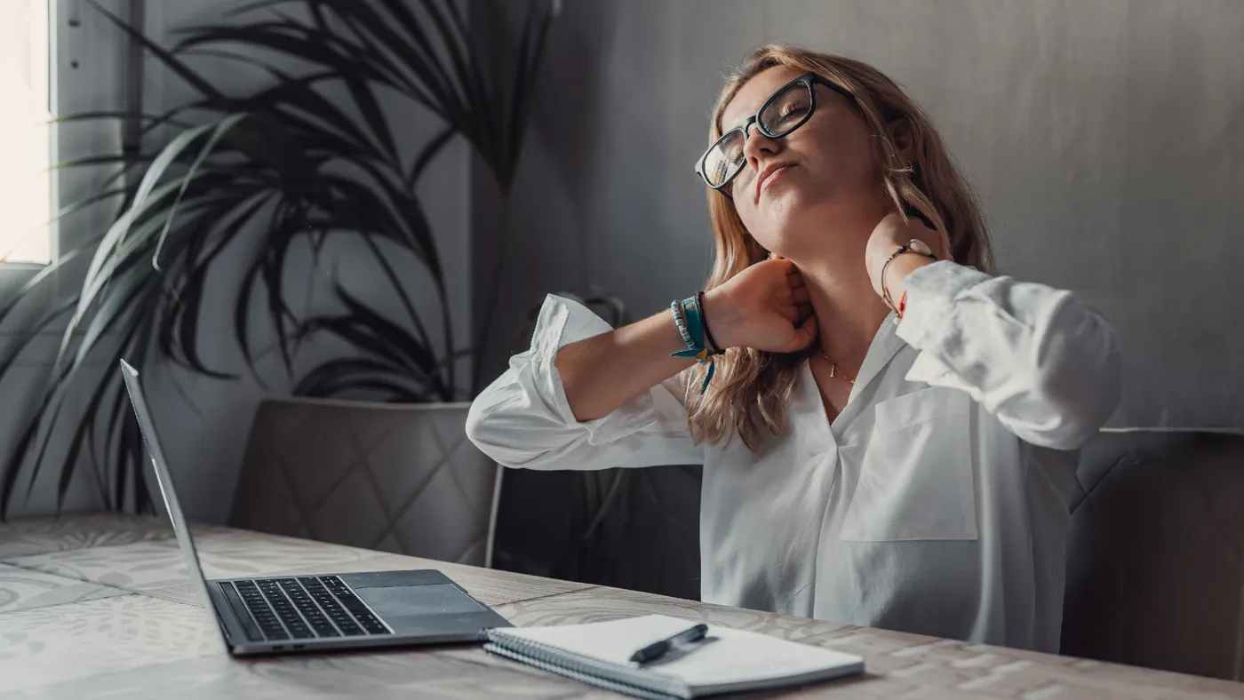 Person stretching at laptop