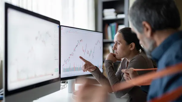 two workers look at a screen