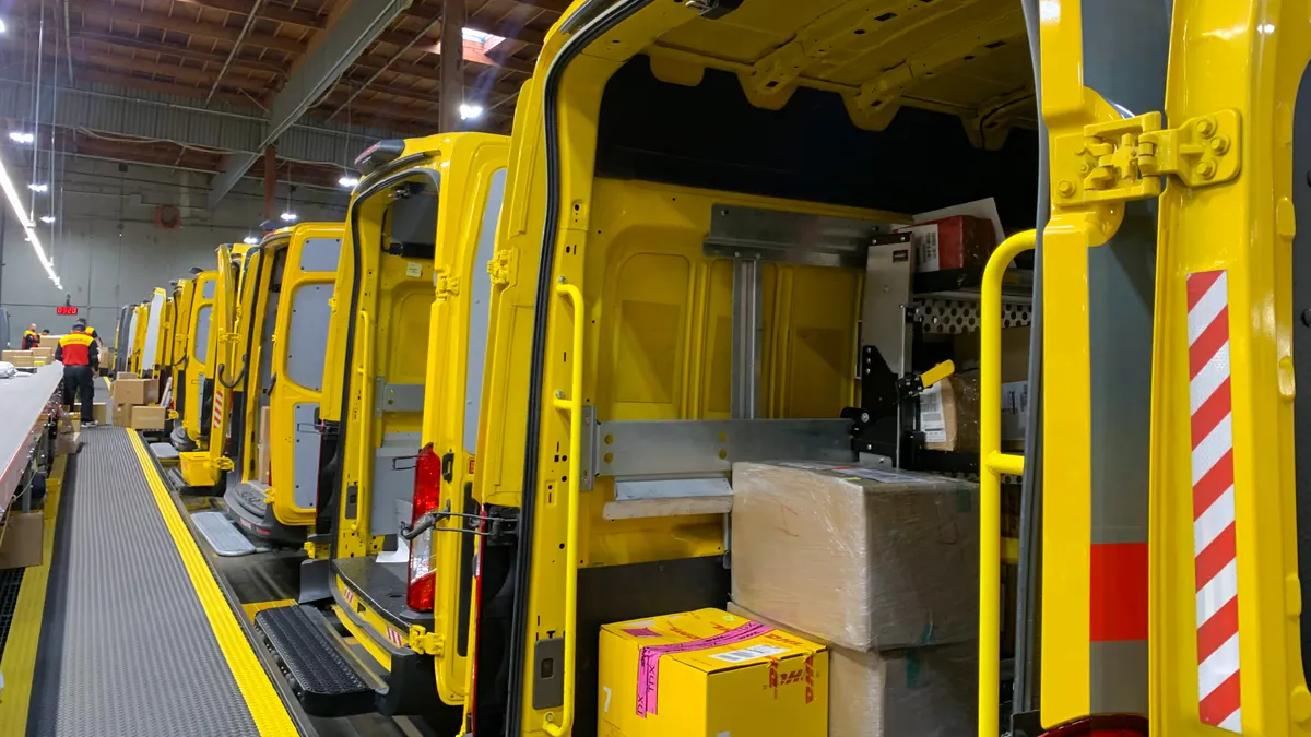 A closeup of the inside of a DHL delivery vehicle with packages stacked inside.