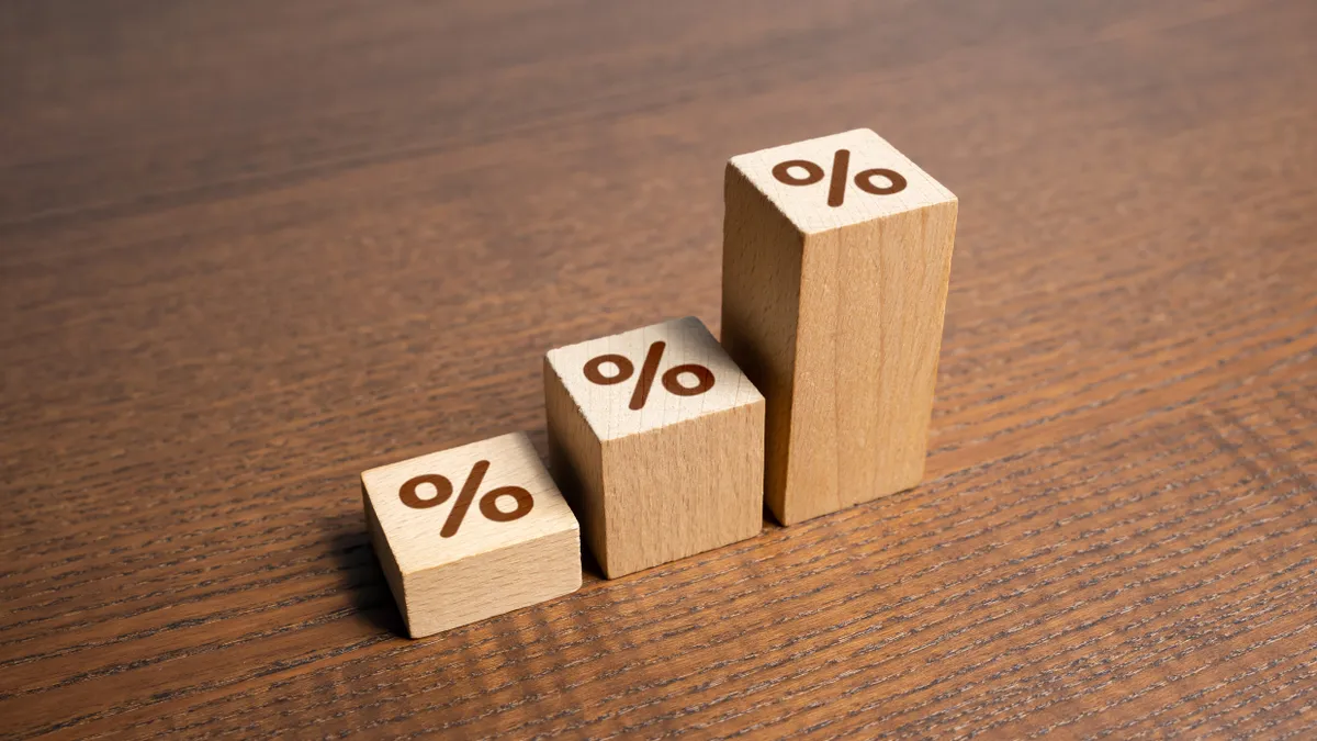 Three wooden blocks of varying heights with the percentage stamped on the end of each one.