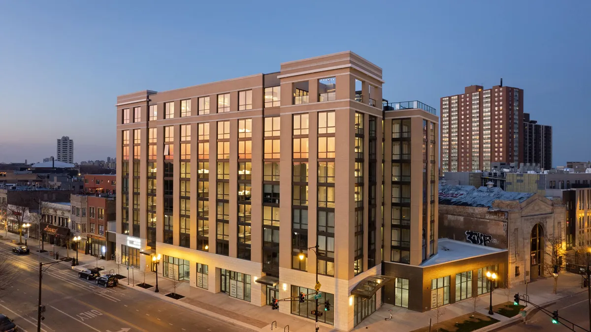 A shot of the outside of mixed-use apartment building Platform 4611 in Chicago. It was taken at dusk, with some light shining off the windows of the mid-rise building.