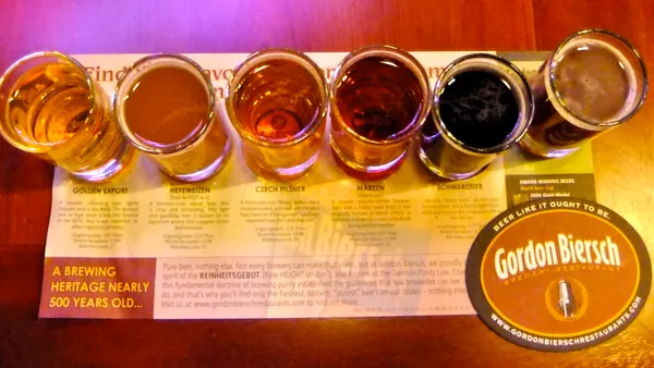 An image of six different beers on a table with a menu below describing each brew.