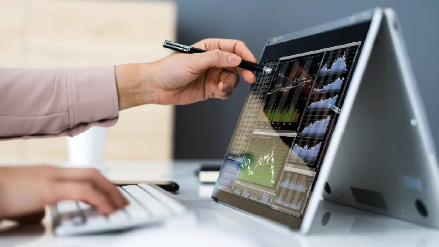 A hand writing something on a tablet with bar graphs.