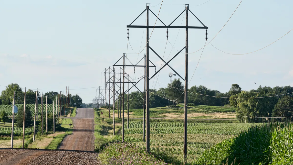 Road and power lines through rolling hills and prairie.