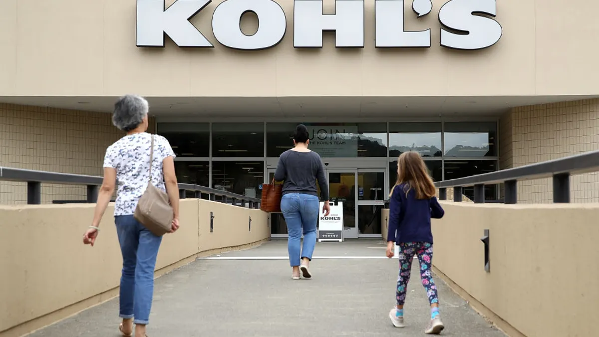 Customers enter a Kohl's store on an elevated walkway.