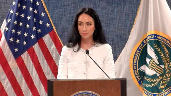 A woman speaks from a podium.
