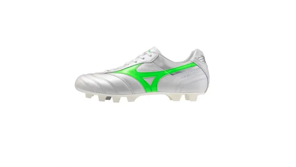 A still life of a white soccer cleat with green stripe accenting.