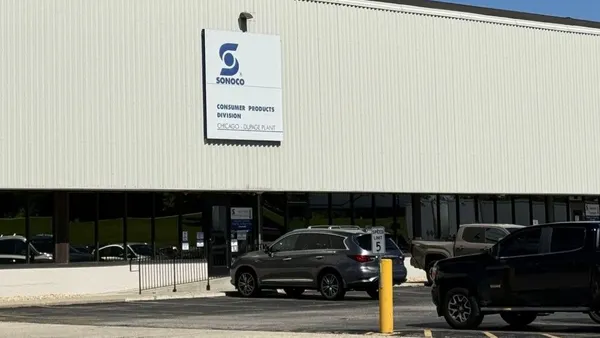 The exterior of a building with a sign that says Sonoco near cars in a parking lot.