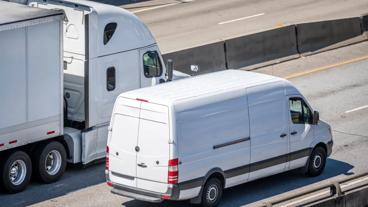 Big rig semi truck with dry van semi trailer and compact cargo mini van driving side by side on the multiline highway