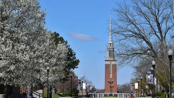 Church spire on college campus rising from the street.