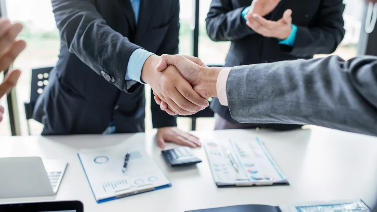 Businessmen handshake at meeting.