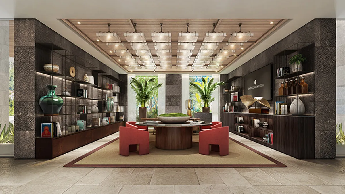 Red couches in a room lined with bookshelves.