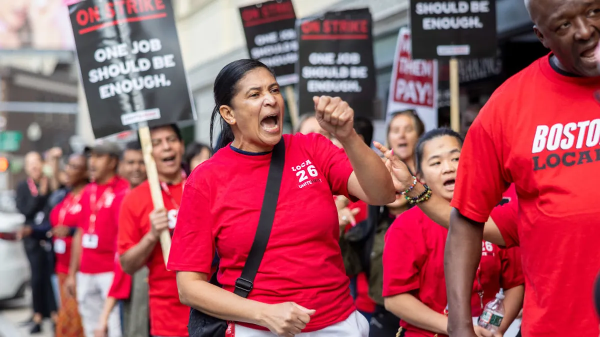 Workers hold signs reading "on strike."