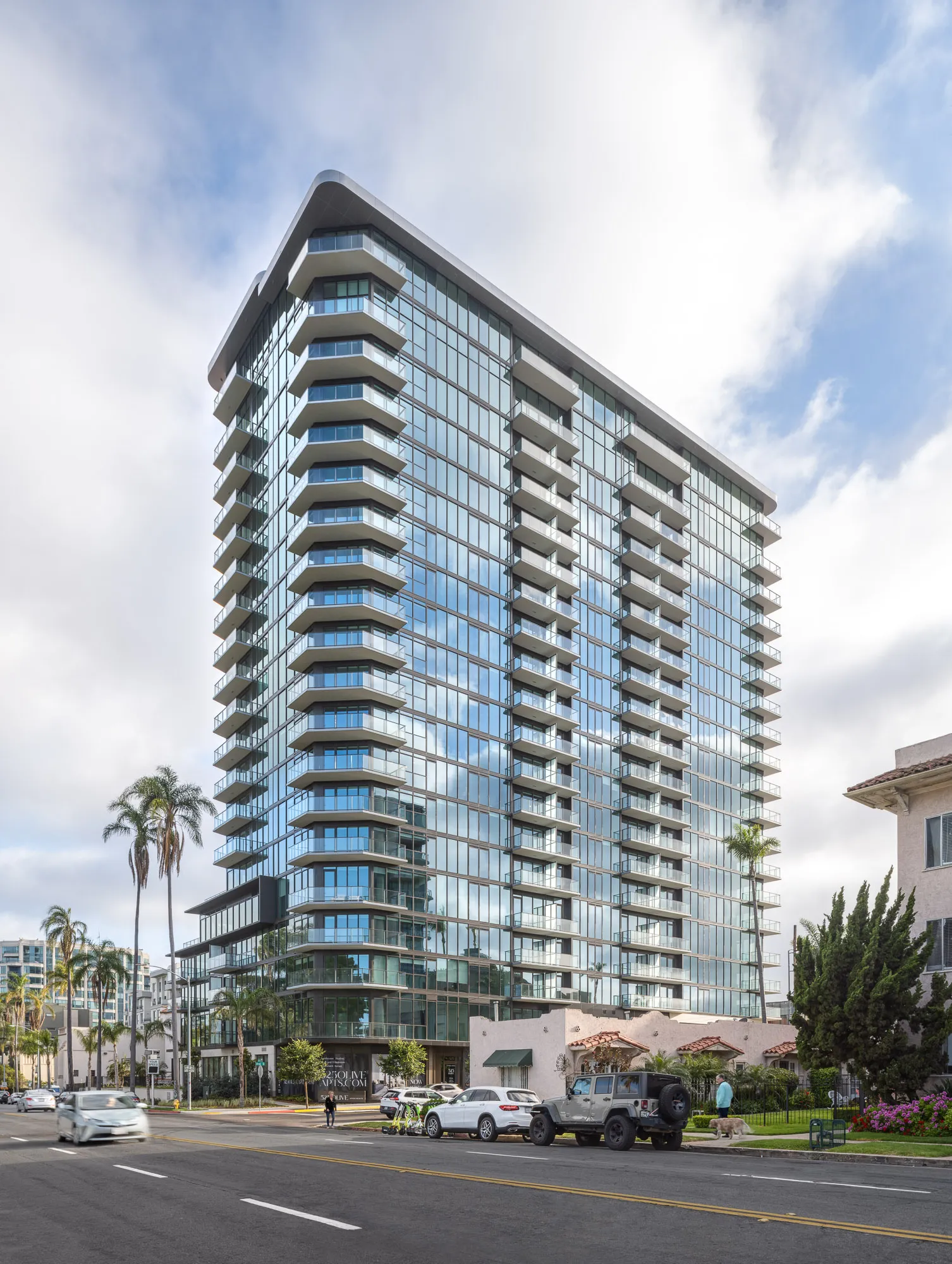 A modern, high-rise apartment building with balconies and glass walls.