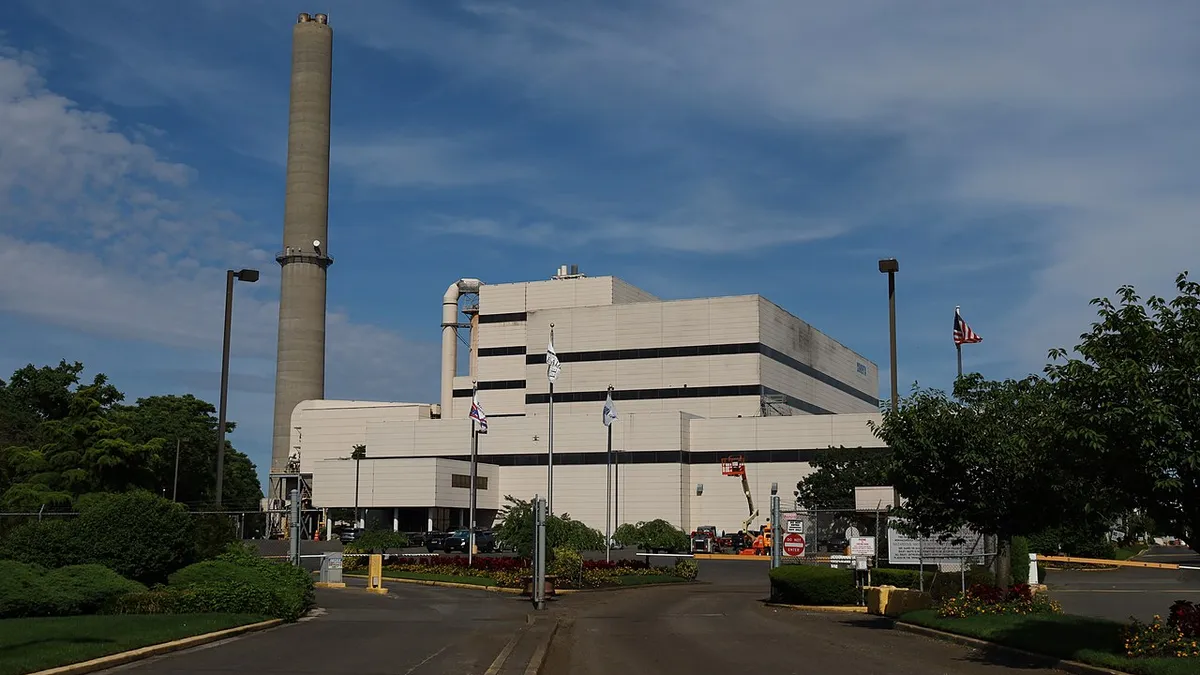 Driveway into an industrial plant with a smokestack