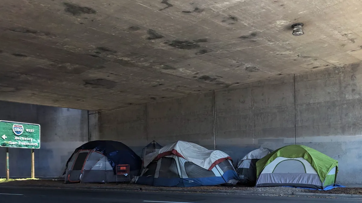 A small tent city under an overpass carrying Interstate 580 in Oakland, California.