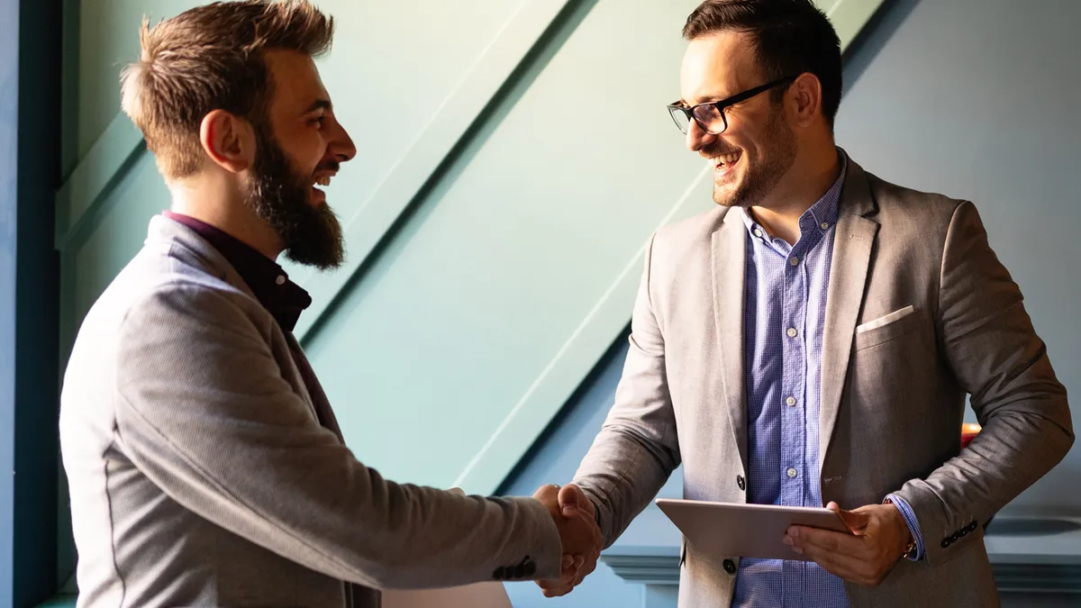 Two professionals shaking hands in an office.