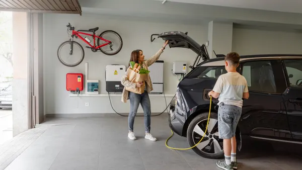 mom and son charging their electric car in the garage