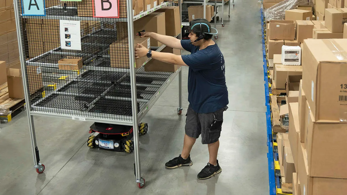 An employee with a headset on organizes packages with a warehouse