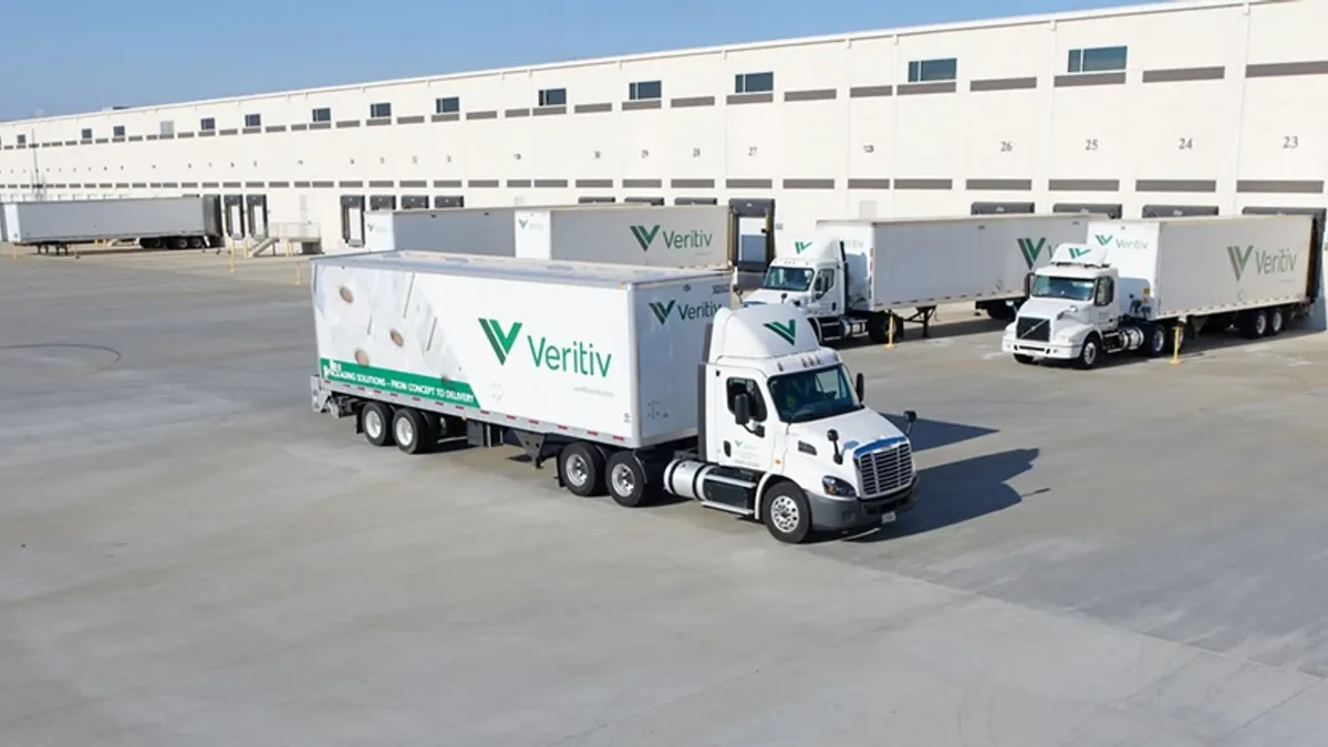 Heavy-duty trucks with the Veritiv logo in front of a warehouse.