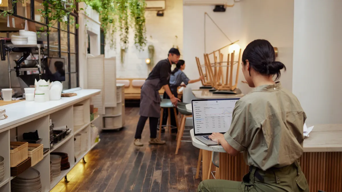 A person on a laptop in a cafe.