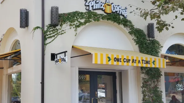 A Philz Coffee location in a white building with ivy on it.