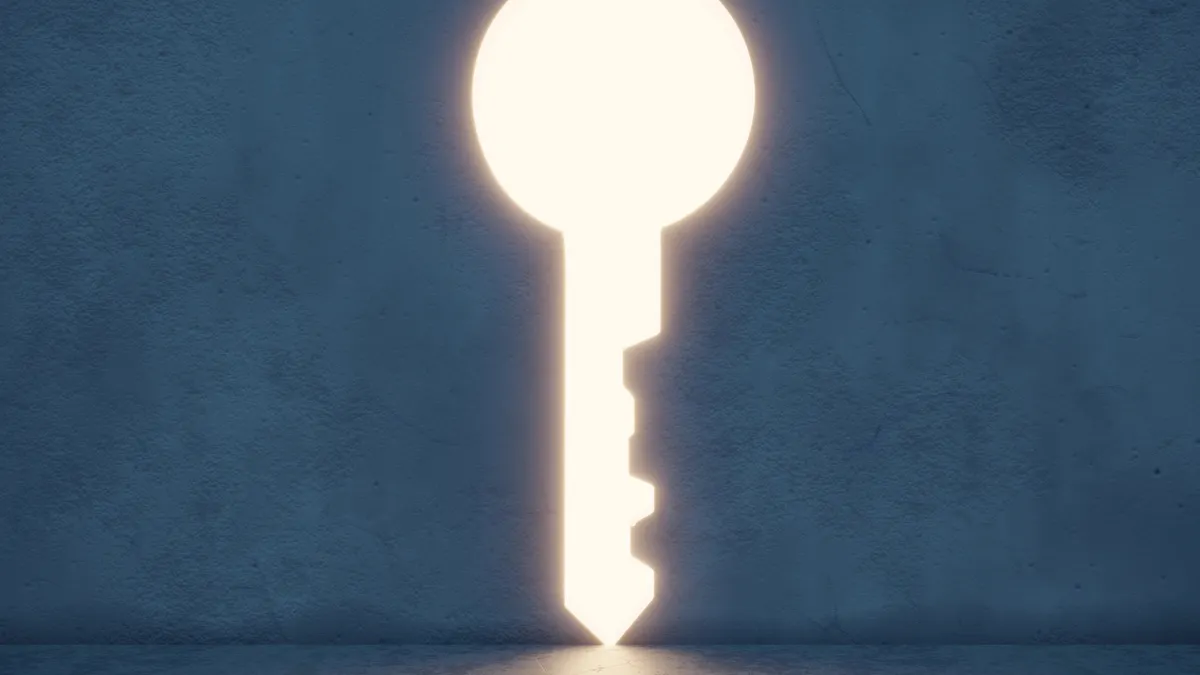 A key-shaped opening in a wall with light pouring through