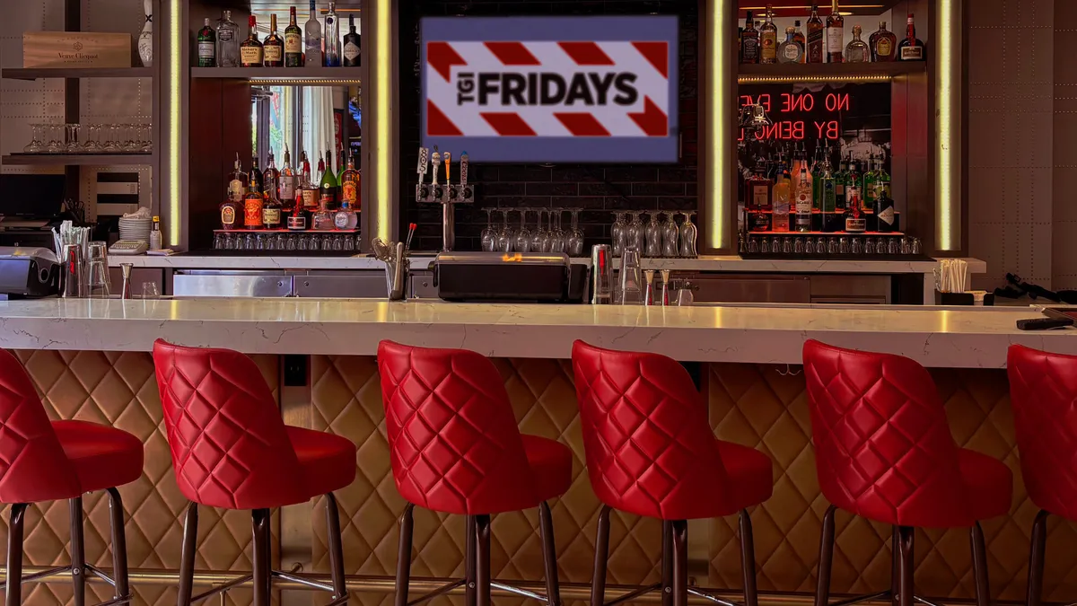 An image of a bar with red chairs and TGI Fridays signage in the background