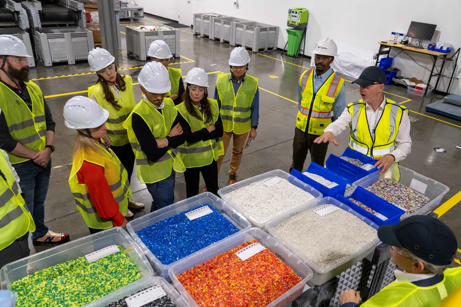 People in hard hats examine recycled materials