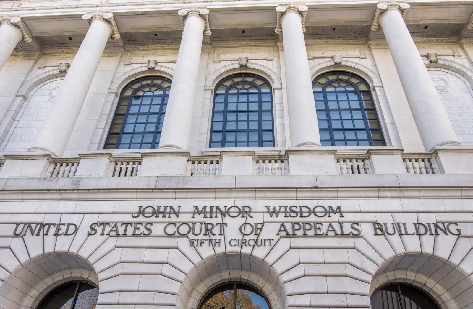 The front facade of a courthouse is shown, bearing the words &quot;John Minor Wisdom United States Court of Appeals Building Fifth Circuit&quot;