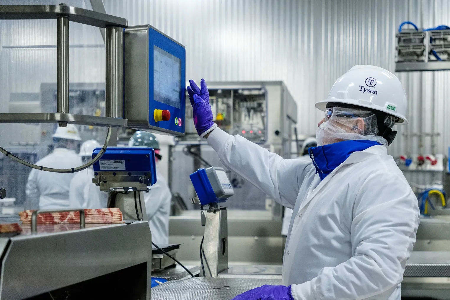 A woman in protective gear stands in front of a machine