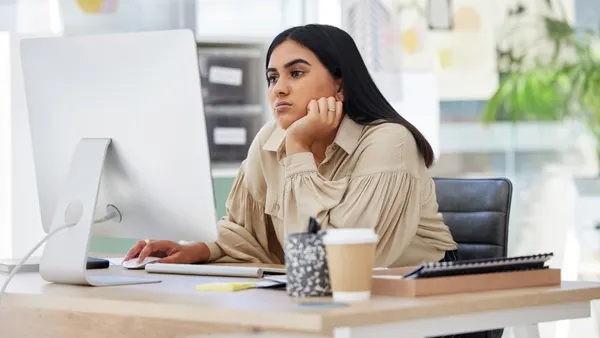 Tired employee working on a computer in the office leaning