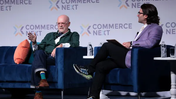 Mickey Drexler speaks to analyst Simeon Siegel on stage at a conference.