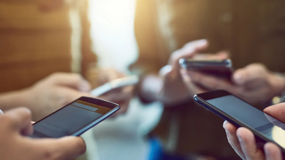 Cropped shot of a group of people on their phones