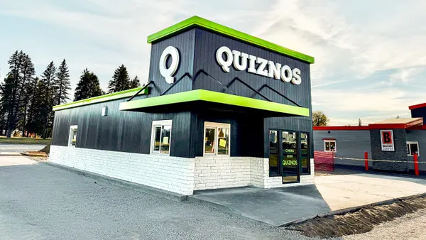 An image of a black building with a green Quiznos logo on top.