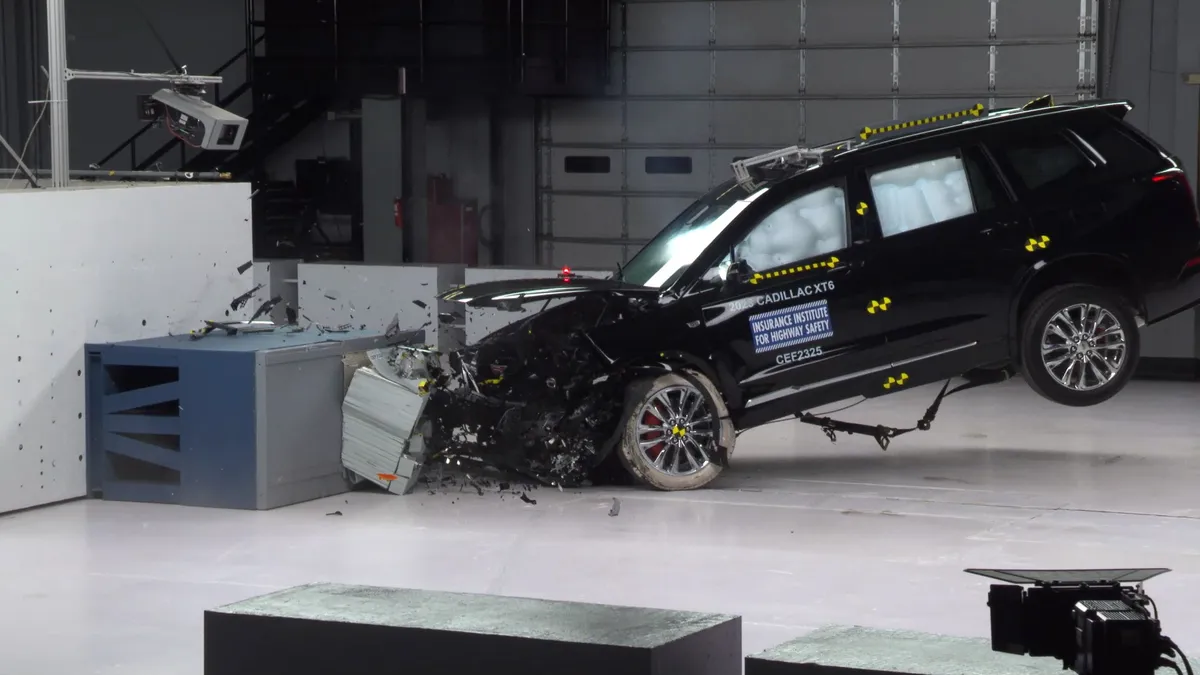 An SUV crashing into a barrier in a test facility.