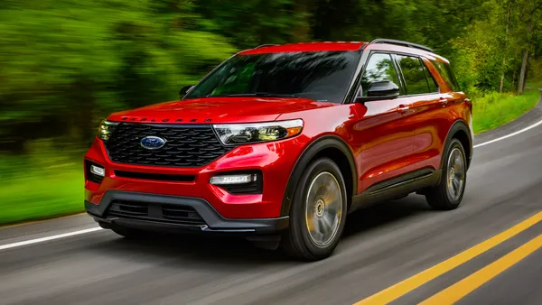 A red 2022 Ford Explorer SUV driving on a road.