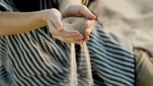 Sand slipping through hands cupped together.
