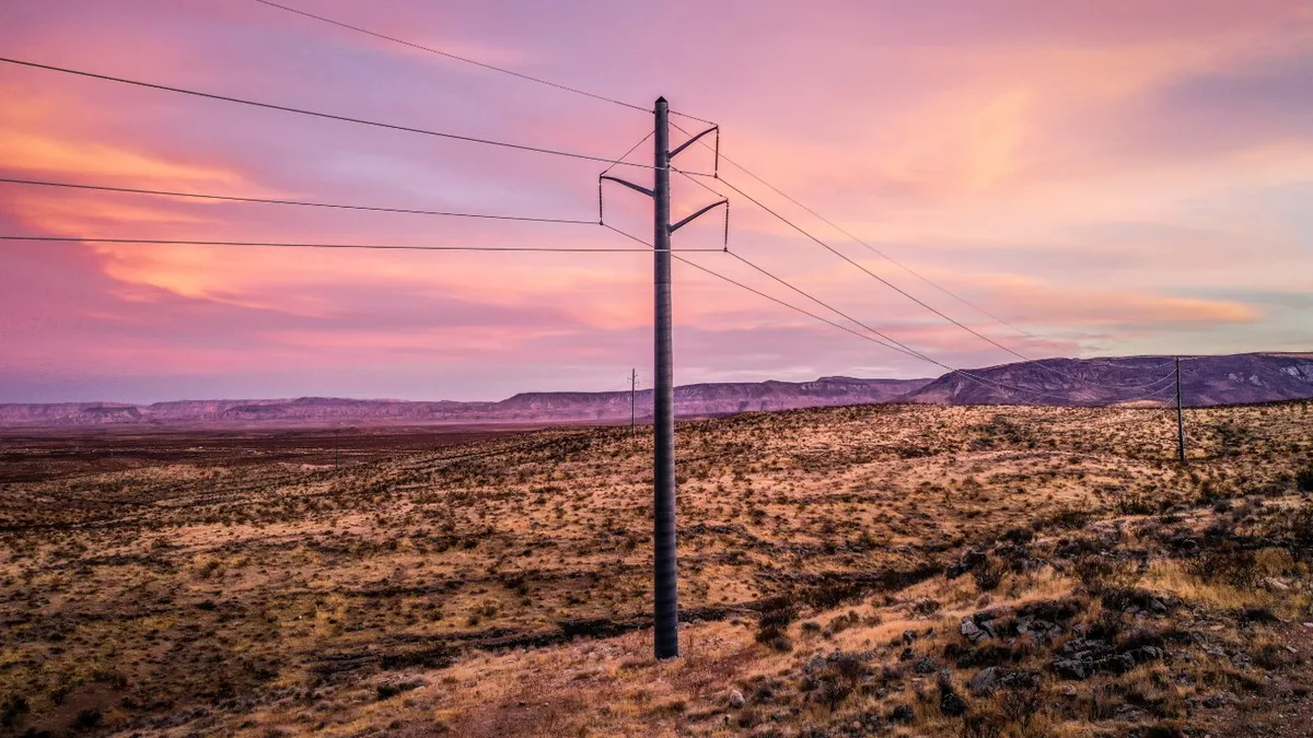 Powerline in desert with purple sunset background