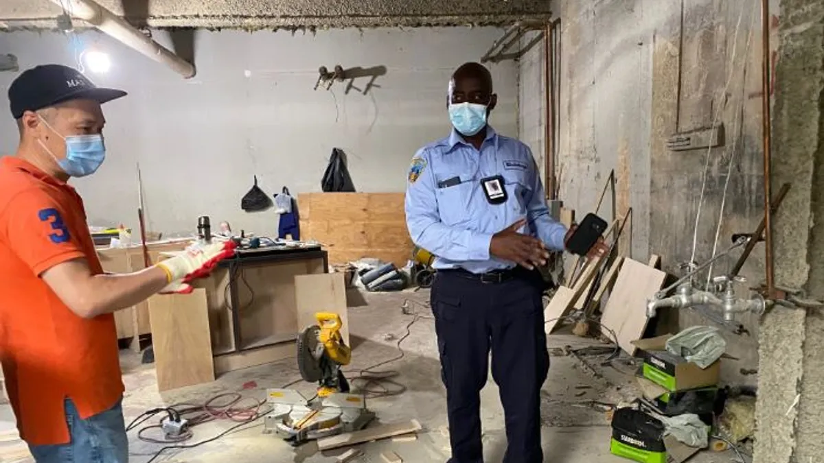 A New York City Department of Buildings inspector talks with a worker next to a hand-washing station during a recent COVID-19 health and safety inspection.