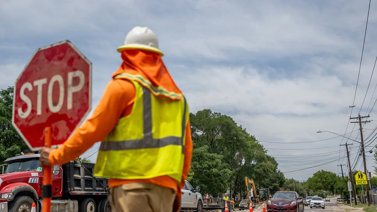 A construction worker ushers traffic on July 11, 2023 in Austin, Texas.