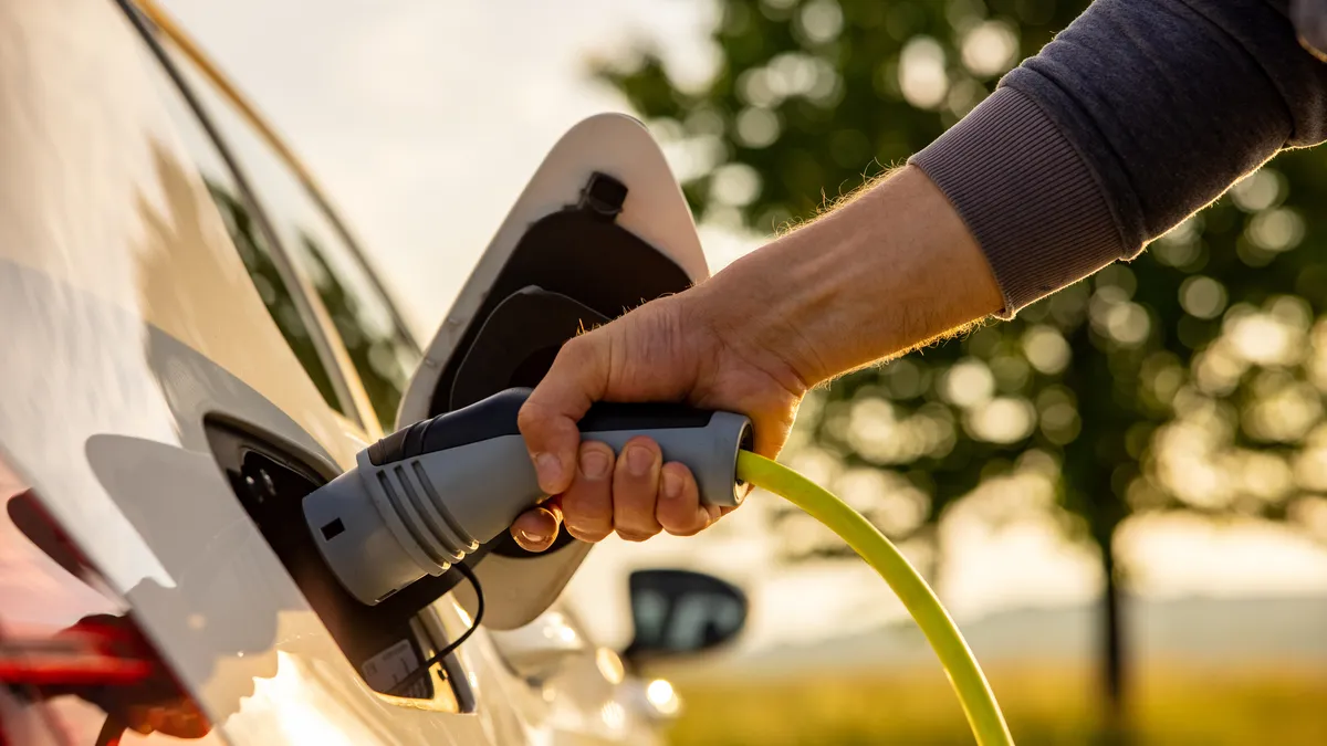 A person charges an electric vehicle.