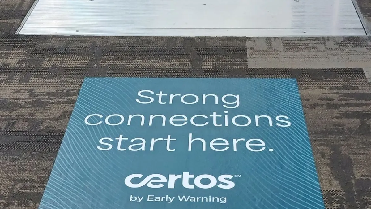 Certos sign attached to carpet in front of escalator.