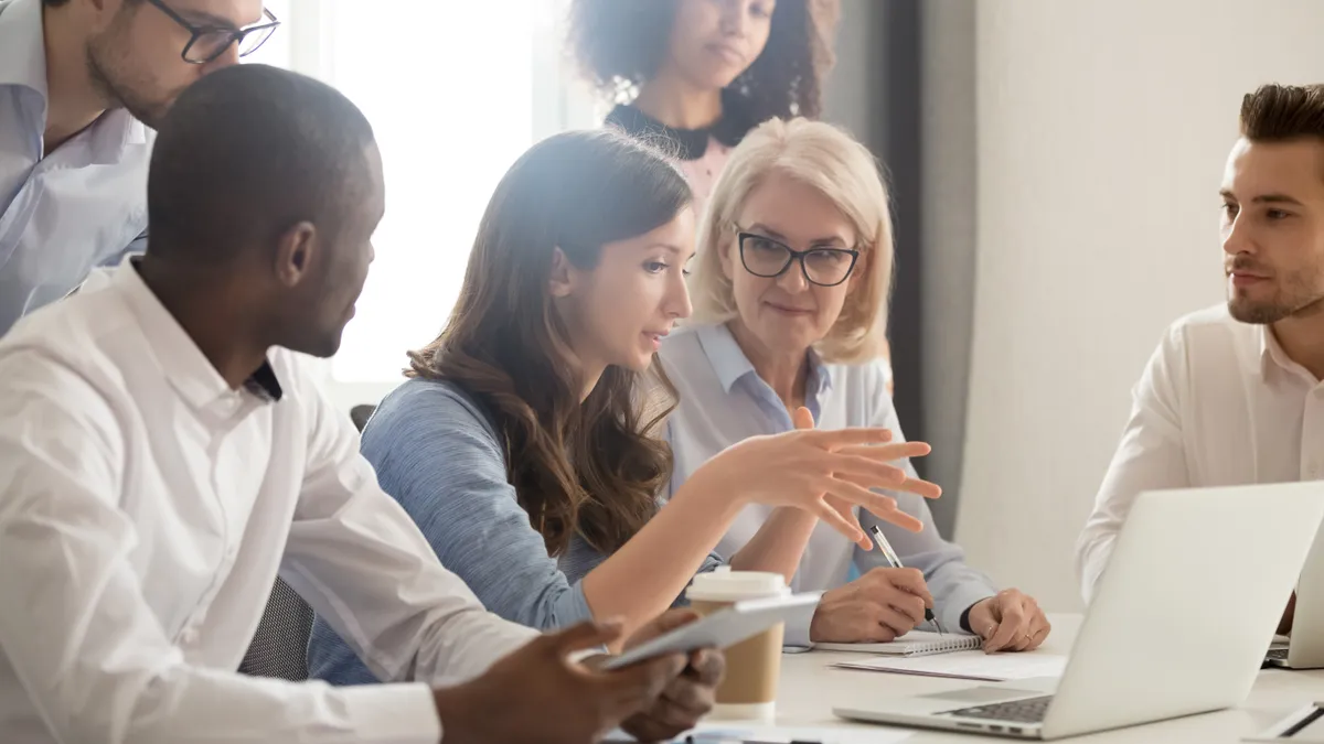 Young female mentor leader coach teaching employees group