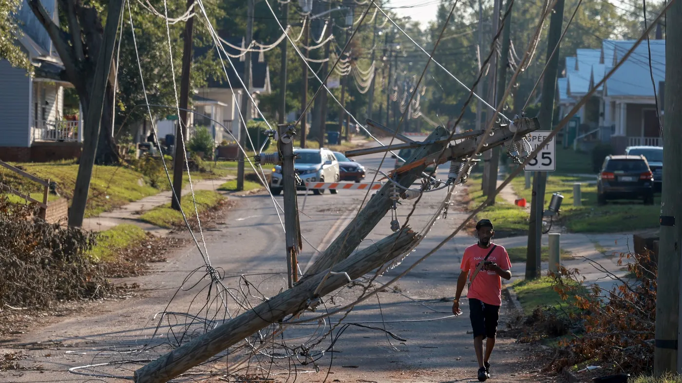 A person walks past downed power lines
