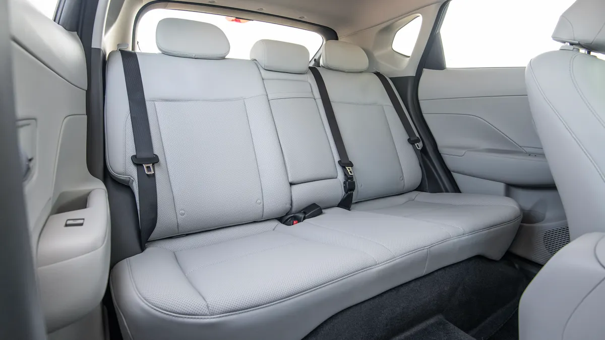 The rear seats in a 2026 Hyundai Kona SUV showing the retracted seat belts and three headrests.