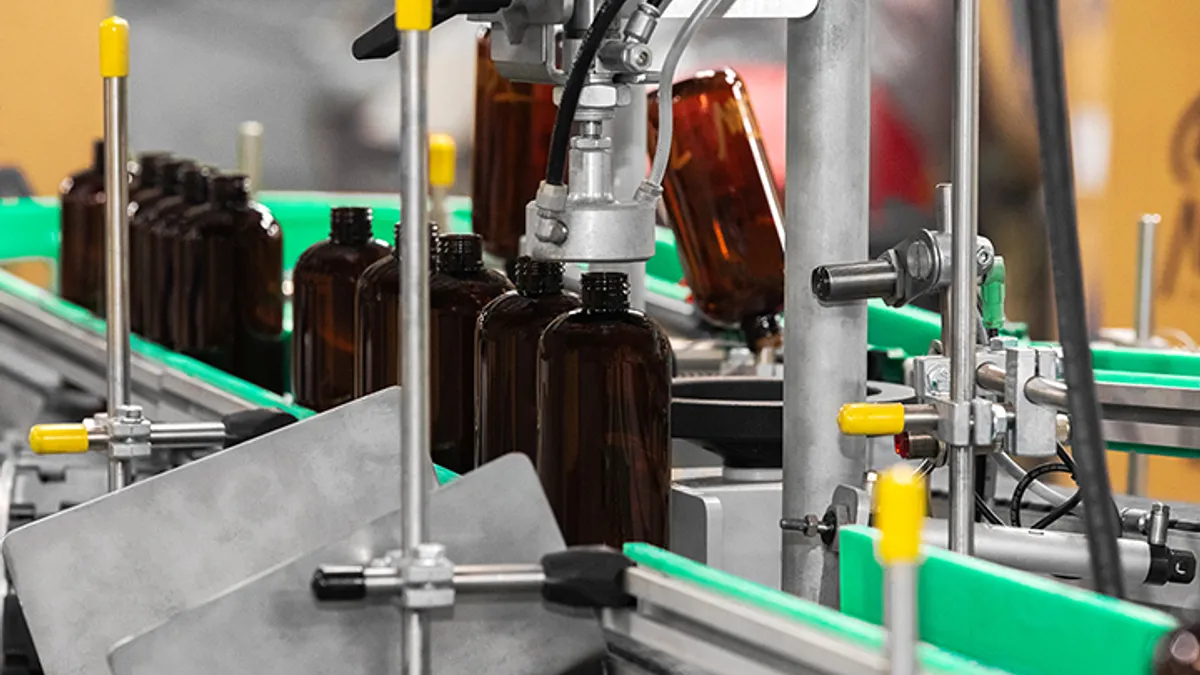 Brown plastic bottles being made on a manufacturing line.