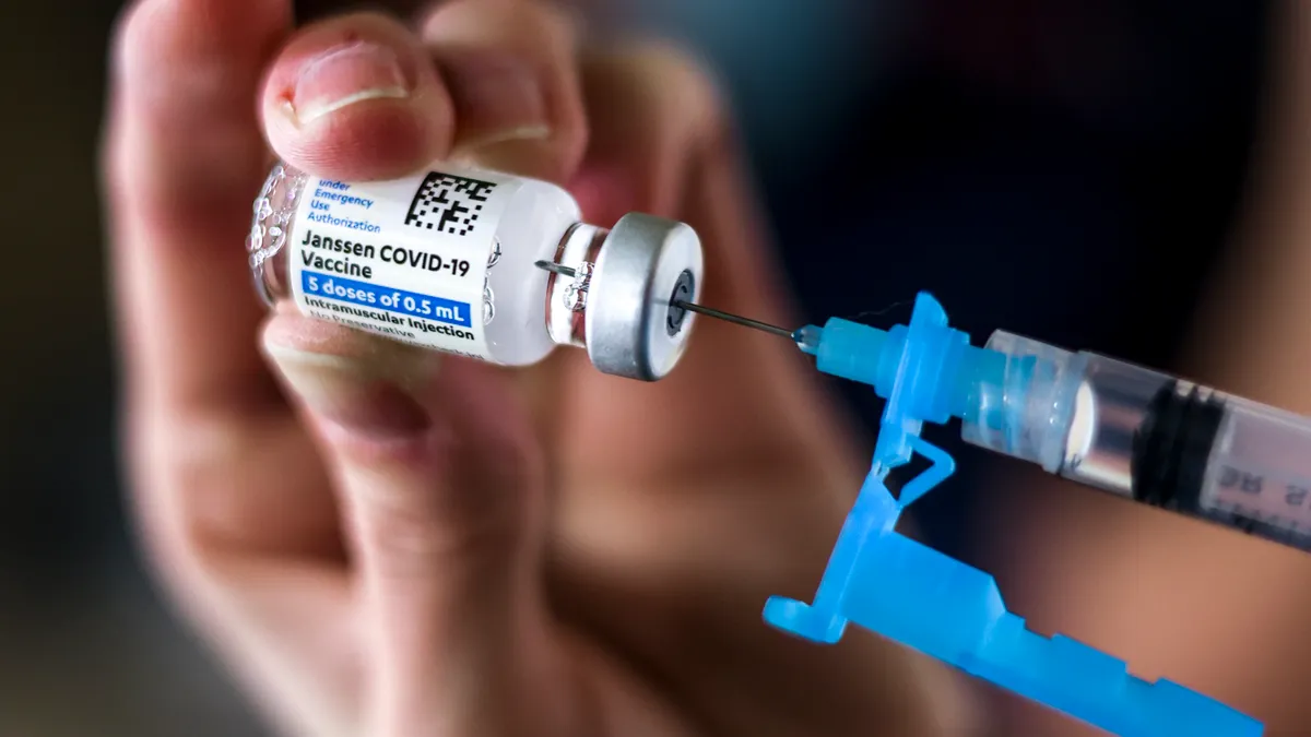 A syringe fills with COVID-19 vaccine.