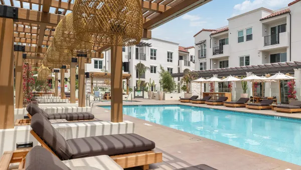Pool with an apartment property in the background.