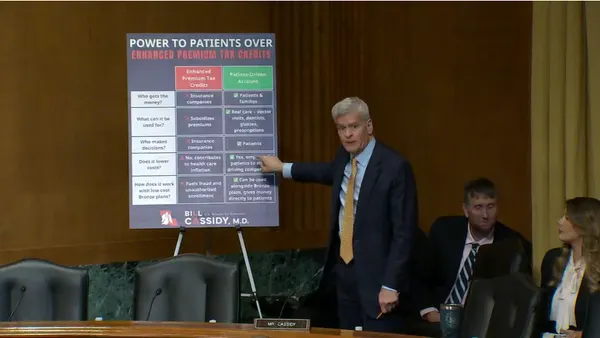 Cassidy speaks in front of poster board during a Senate Finance Committee hearing.